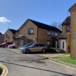 Cars parked on driveways in Swindon on a sunny day.